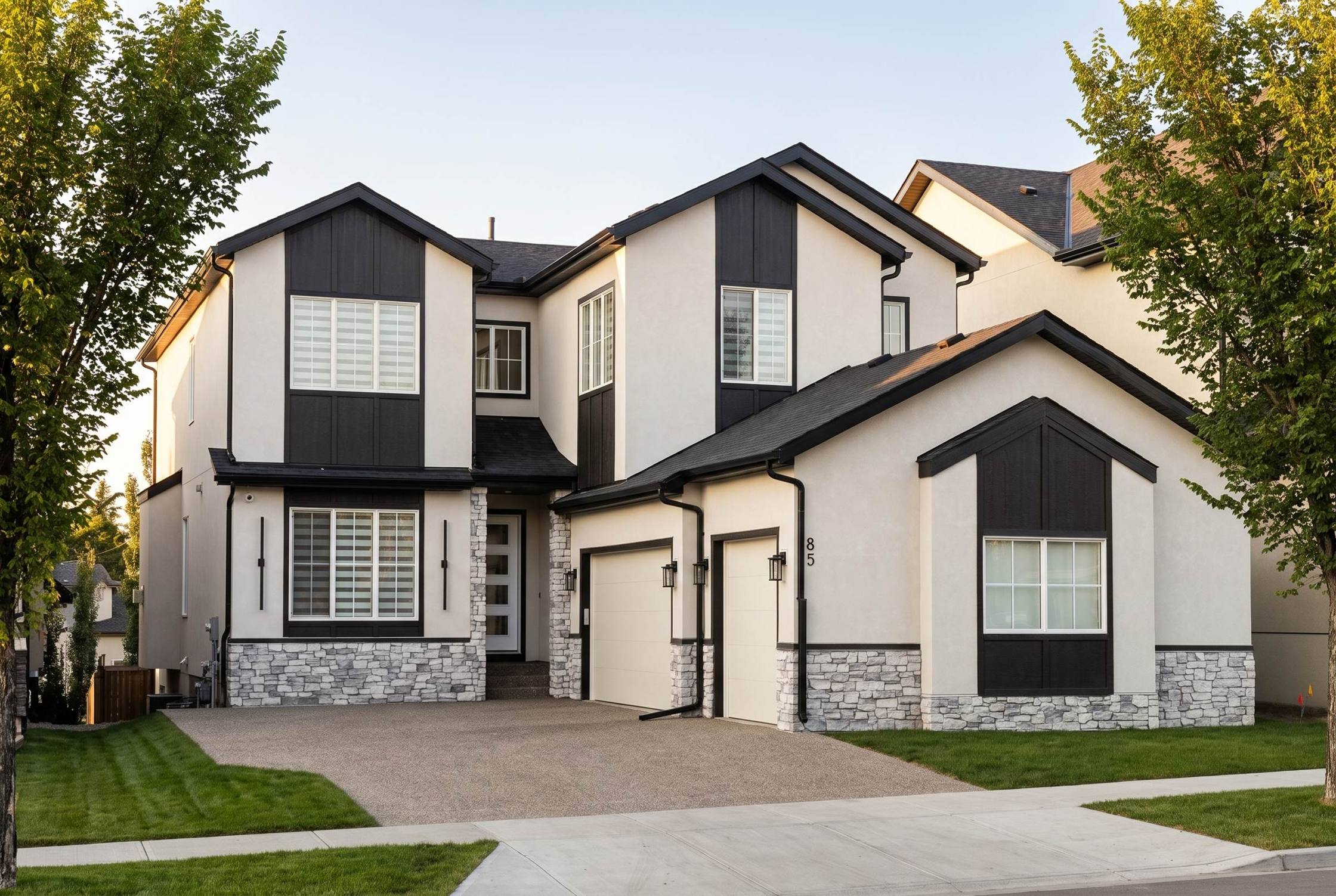 A completed Brar Homes estate home: cream stucco with dark gables and a stone base