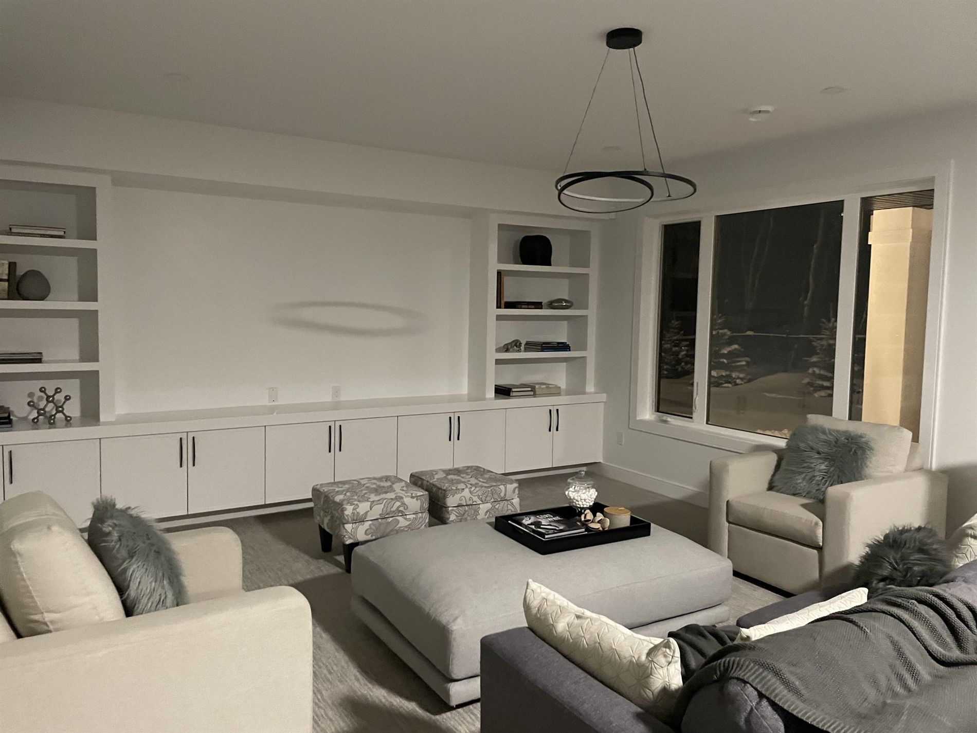 Family room with a sectional and built-ins at night