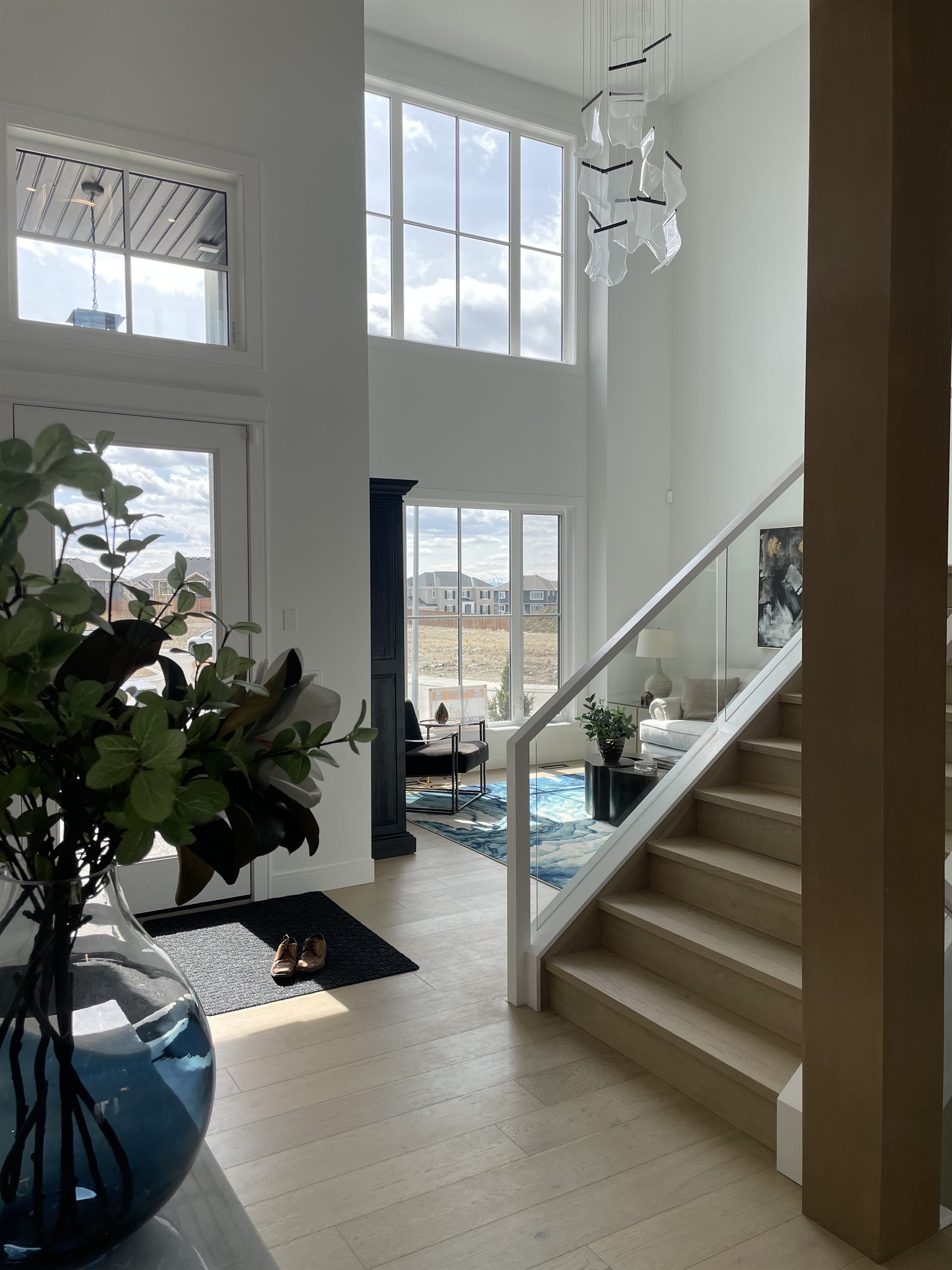 Two-storey foyer with a glass-railed staircase in daylight
