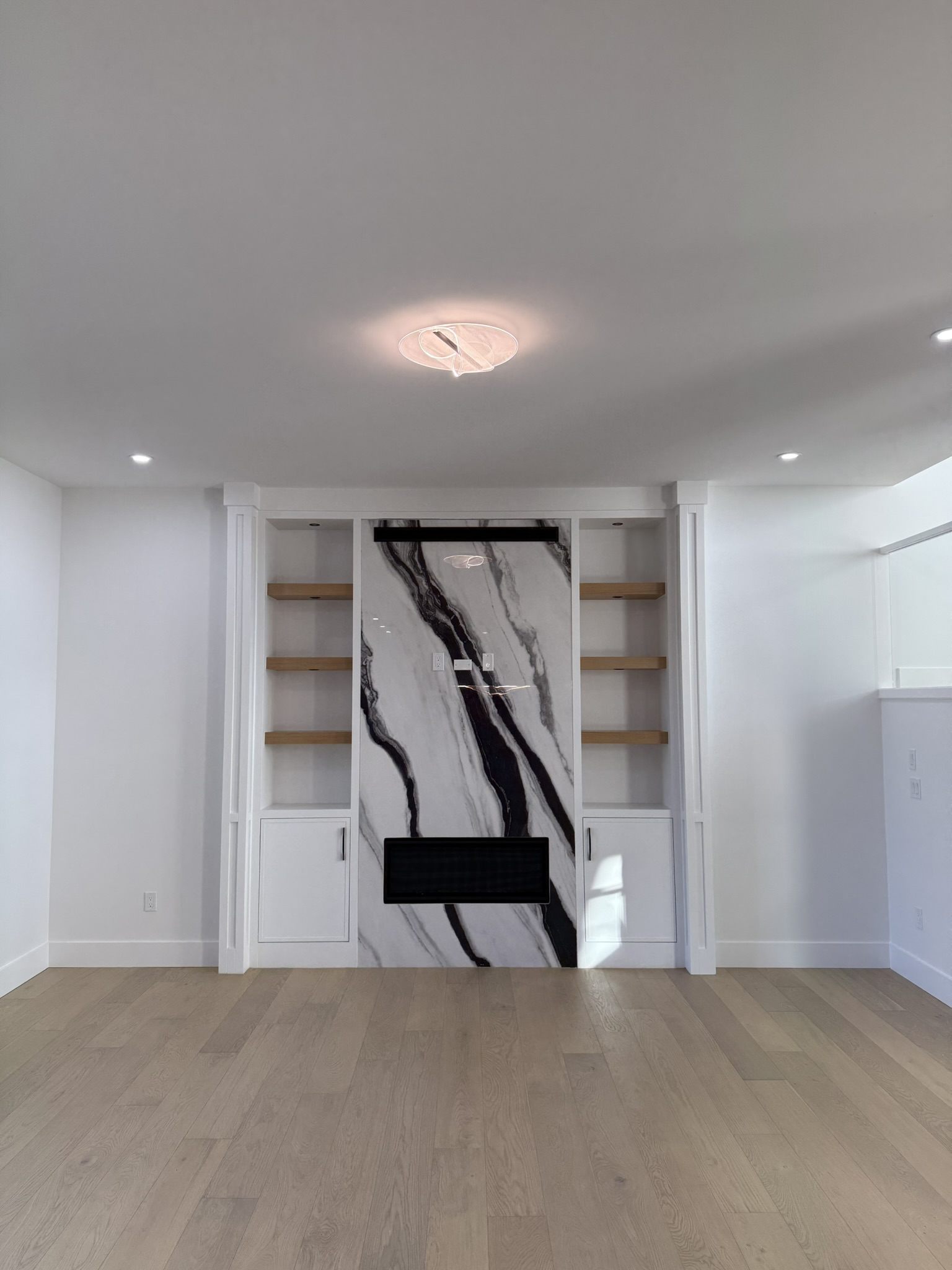 Fireplace wall with a marble slab and built-in shelving