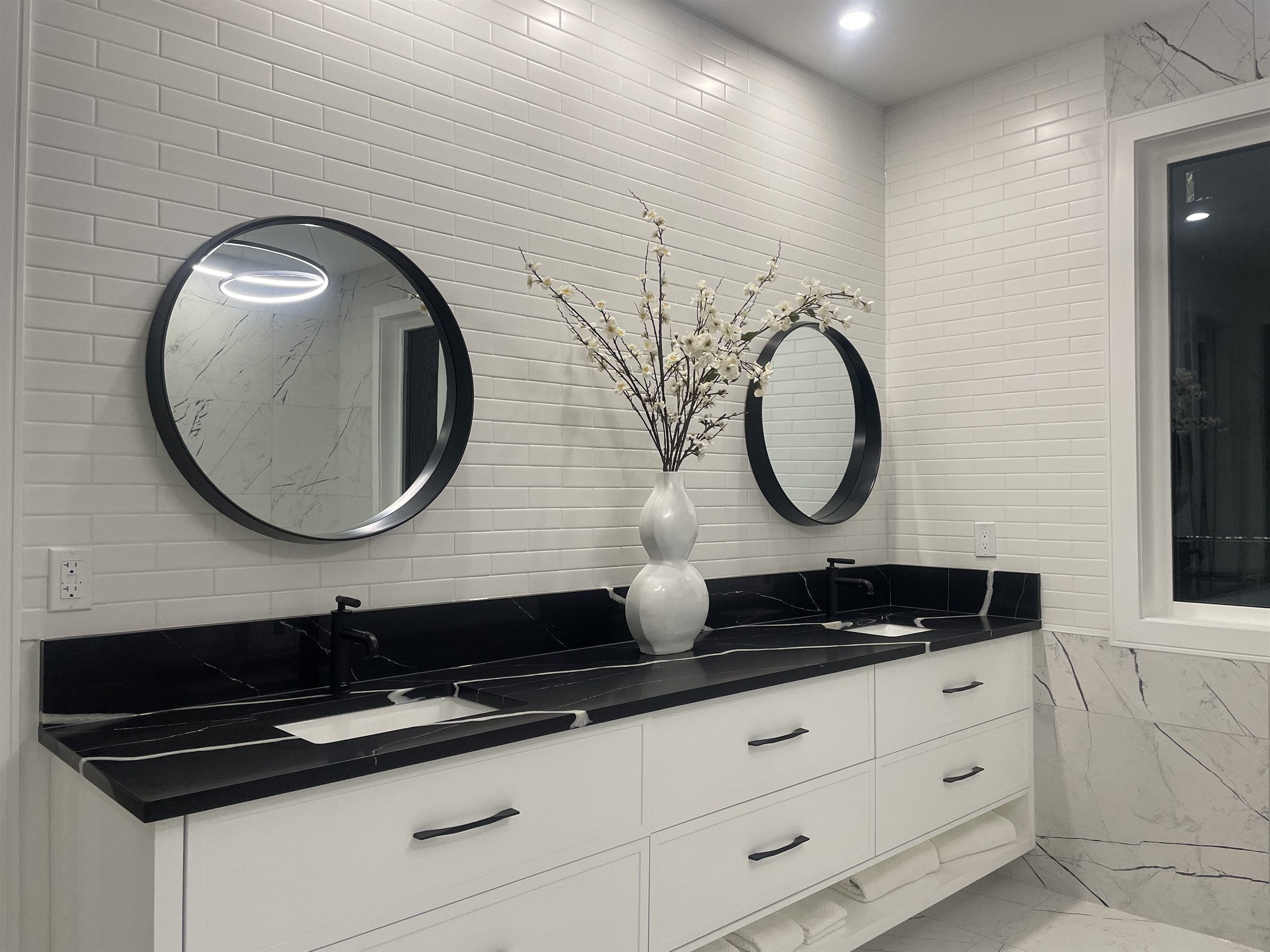 Primary bathroom with a black marble double vanity